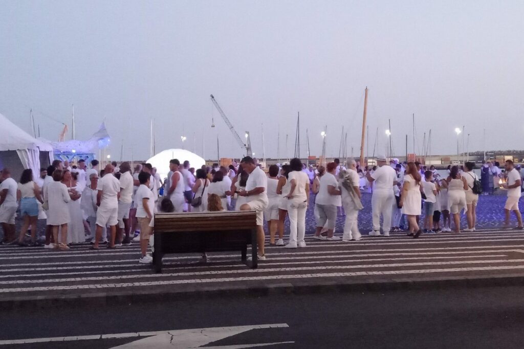 Summer festival crowd in Ponta Delgada marina, São Miguel Azores, people dressed in white during evening celebration