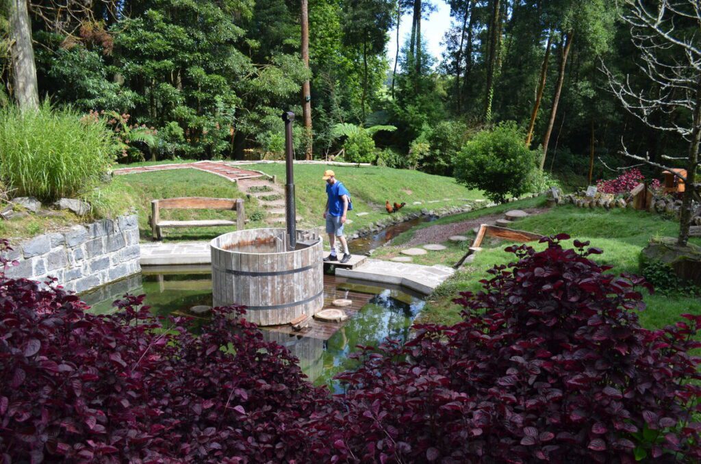 Walking in Parque Grena Furnas entrance surrounded by lush vegetation São Miguel Azores